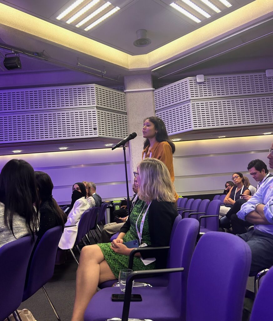 Photograph of Palak with a microphone asking a question during Professor Ahmed's lecture.